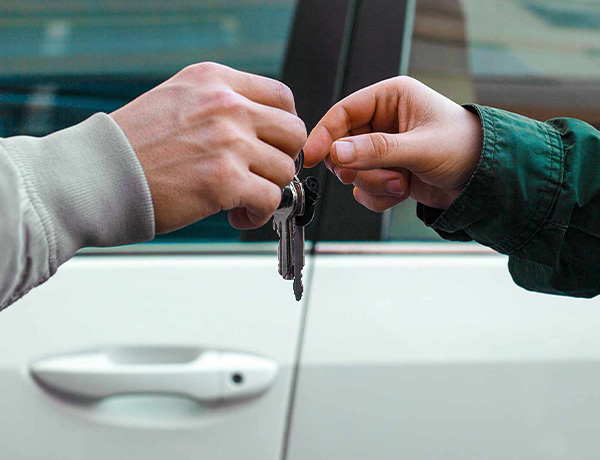 Vehicle keys being handed to a new owner